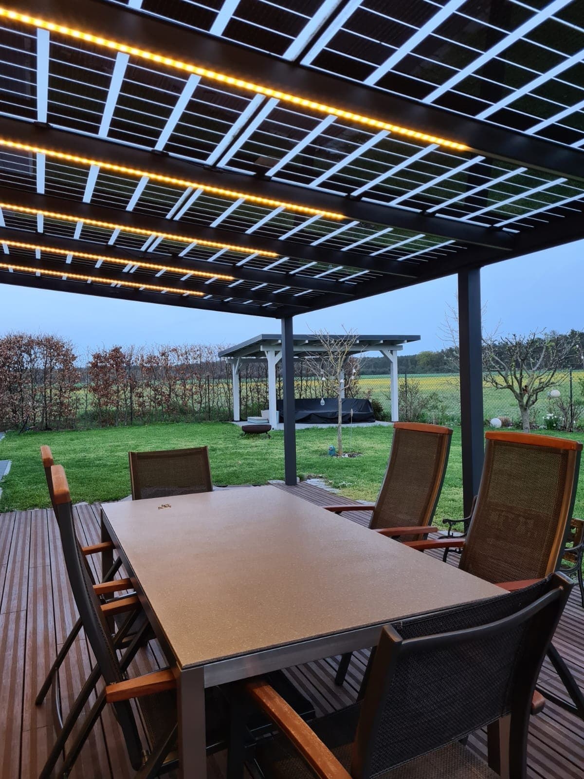 Solar-Terrassenüberdachung bei Dämmerung mit warmer LED-Beleuchtung